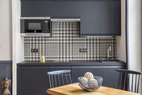 une cuisine avec des placards bleus et une table en bois dans l'établissement Le Secret, climatisé, Place des Terreaux-Lyon 1er, à Lyon