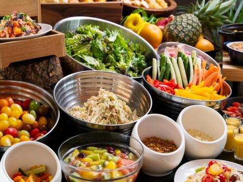 石垣岛FUSAKI BEACH RESORT HOTEL & VILLAS的桌子上放着各种蔬菜碗