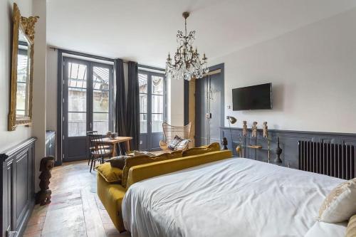 une chambre avec un grand lit et un lustre dans l'établissement Le Secret, climatisé, Place des Terreaux-Lyon 1er, à Lyon