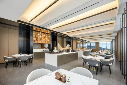 a restaurant with tables and chairs and a bar at Atour Hotel Dongguan Huangjiang Xingguang Road in Dongguan
