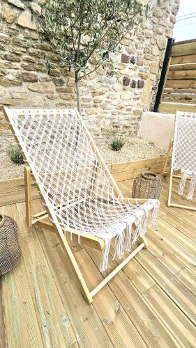 un banc blanc assis au-dessus d'une terrasse en bois dans l'établissement La maison du Pays d'Auge, à Troarn