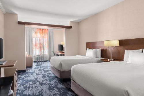 a hotel room with two beds and a television at Fairfield Inn & Suites by Marriott Alexandria in Alexandria