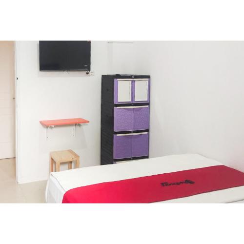 a room with a bed with purple and purple boxes at RedDoorz near Grand Tarakan Mall in Klapa