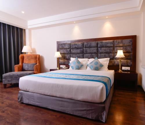 a bedroom with a large bed and a chair at Tsokar Retreat in Leh