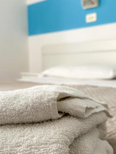 a pile of towels sitting on top of a bed at Hotel Serafini in Rimini