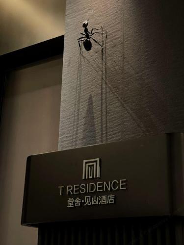 a sign for a restaurant with a insect on it at Phoenix Hall House Hotel in Fenghuang