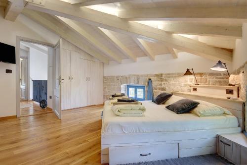 a bedroom with two large beds in a room with wooden floors at Villa PI for 8 people in Central Istria with heated pool & large garden in Tinjan