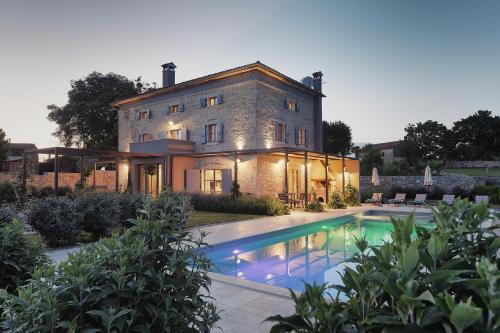 a house with a swimming pool in front of it at Villa PI for 8 people in Central Istria with heated pool & large garden in Tinjan