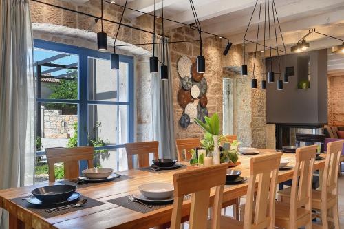 a dining room with a wooden table and chairs at Villa PI for 8 people in Central Istria with heated pool & large garden in Tinjan