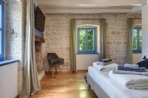 a bedroom with two beds and a brick wall at Villa PI for 8 people in Central Istria with heated pool & large garden in Tinjan