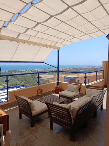 a patio with chairs and a table and an umbrella at Panoramic Atalaya in Mojácar