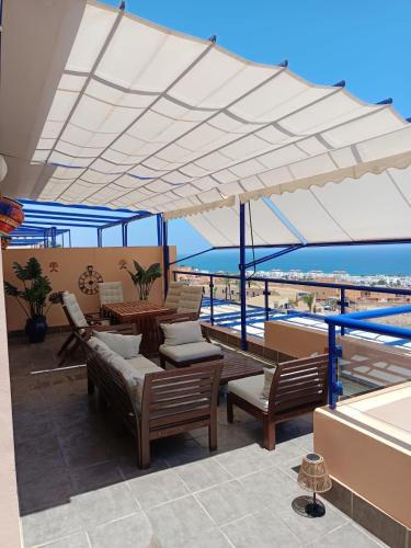 a patio with chairs and tables under a white canopy at Panoramic Atalaya in Mojácar
