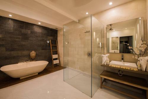 a bathroom with a tub and a sink and a shower at 20 off Special Brilliant Location in Seminyak