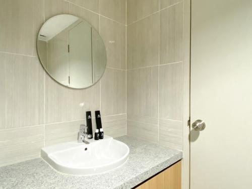 a bathroom with a sink and a mirror at Best Homey 1BR at 25th Floor Vasanta Innopark Apartment By Travelio in Cikarang
