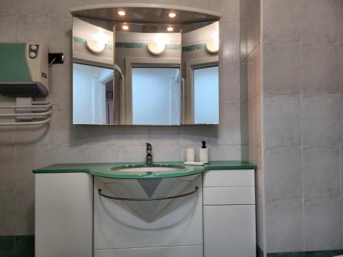 ein Badezimmer mit Waschbecken und Spiegel in der Unterkunft Cannes Paradis in Cannes