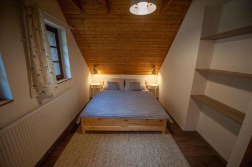 a small bedroom with a bed in a attic at Apartmán Stodola2 Harrachov in Harrachov