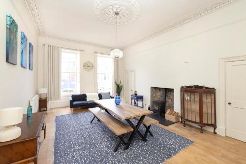 a living room with a table and a fireplace at JOIVY Exclusive house with free parking in Edinburgh