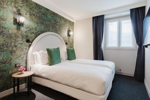 ein Hotelzimmer mit einem Bett und einem Fenster in der Unterkunft Hotel Prince Albert Opéra in Paris