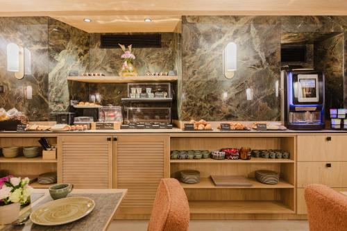 ein Restaurant mit einer Theke und einem Tisch mit Stühlen in der Unterkunft Hotel Prince Albert Opéra in Paris