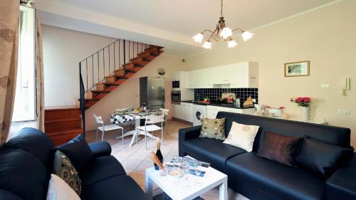 a living room with a blue couch and a kitchen at Villa Isella - Mansarda in Carlazzo