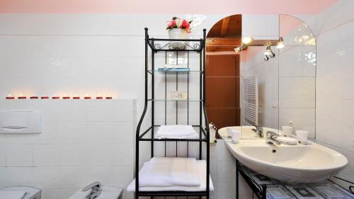 a bathroom with a sink and a shelf with towels at Villa Isella - Mansarda in Carlazzo