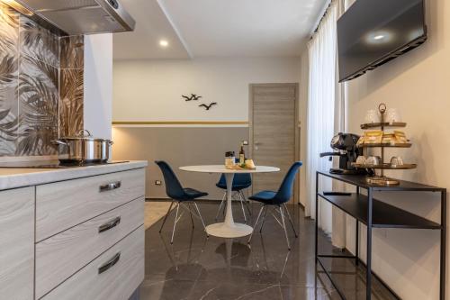 a kitchen with a table and blue chairs at Golden View Holidays in La Spezia