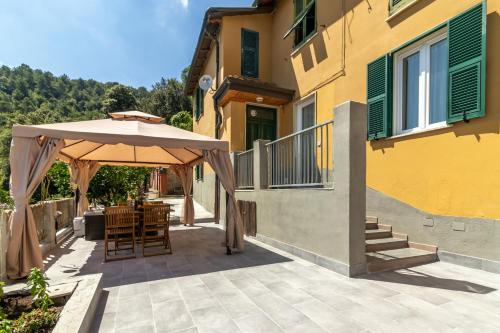 a patio with an umbrella and a table and chairs at Golden View Holidays in La Spezia