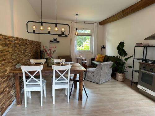 a kitchen and living room with a table and chairs at Hoeve de Binnenplaets Schimmert in Schimmert