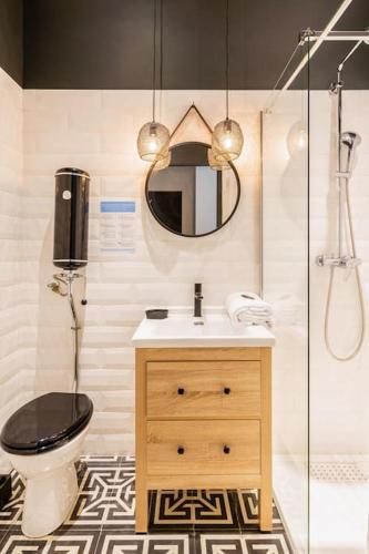 une salle de bain avec toilettes, lavabo et miroir dans l'établissement Milan, centre historique et climatisé, Lyon 1er, à Lyon