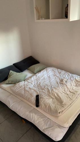 - un lit blanc avec télécommande dans l'établissement Studio cosy, à Aubervilliers