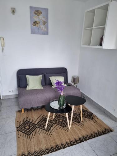 un salon avec un canapé violet et une table dans l'établissement Studio cosy, à Aubervilliers