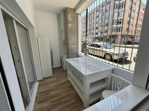 een kamer met een bureau en een groot raam bij Apartamentos Torres del Milladoiro in Amés