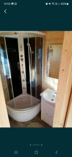 a bathroom with a shower and a sink at Domki Cichy Zakątek in Darłowo