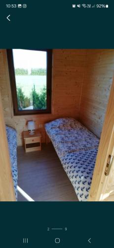 a small bedroom with a bed and a window at Domki Cichy Zakątek in Darłowo