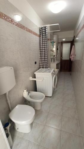 a white bathroom with a toilet and a sink at Casa Stella Terminal in Perosa Argentina