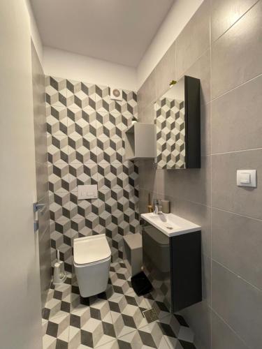 a bathroom with a toilet and a sink at Sunrise Apartments - Onix Pipera in Bucharest