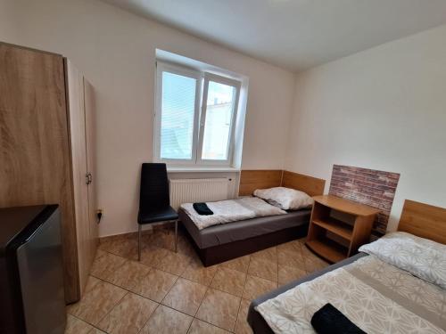 a room with a bed and a couch and a window at Penzión ACCOM in Trenčín