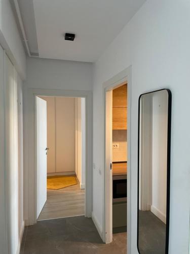 a mirror in a white room with a hallway at Sunrise Apartments - Onix Pipera in Bucharest