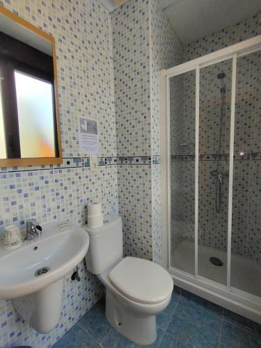 a bathroom with a toilet and a sink and a shower at Hostal Abastos in Valencia