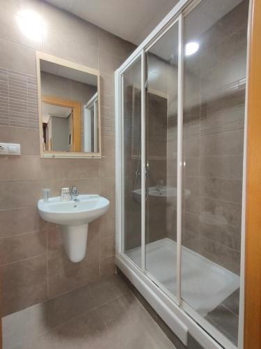 a bathroom with a glass shower and a sink at Hostal Abastos in Valencia