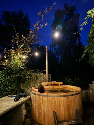 a wooden tub with a cat sleeping in it at night at Domek w Brzezowej in Brzezowa