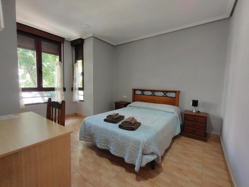 a bedroom with a bed with two towels on it at Hostal Abastos in Valencia