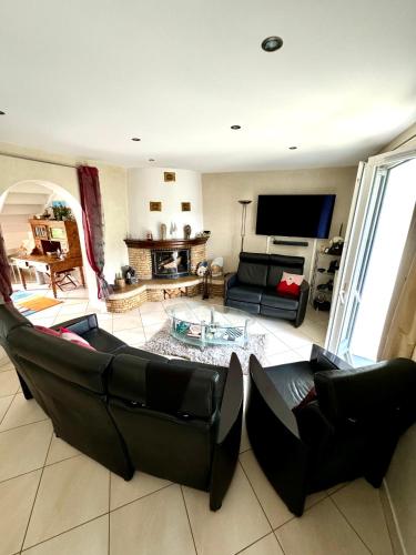 a living room with a couch and a tv at Emeraude in Gex