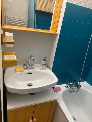 une salle de bain avec un lavabo, un miroir et une baignoire dans l'établissement Appartement Morzine, deux pièces, mezzanine, 4 personnes, à Morzine