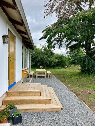 a porch with a picnic table next to a house at Krokens Gård in Fotskäl