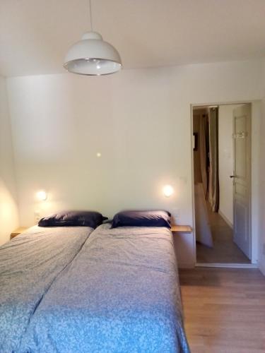 une chambre avec un lit avec deux oreillers dessus dans l'établissement charmant logis avec vue sur l'Hérault pour 4 personnes à Aniane, à Aniane