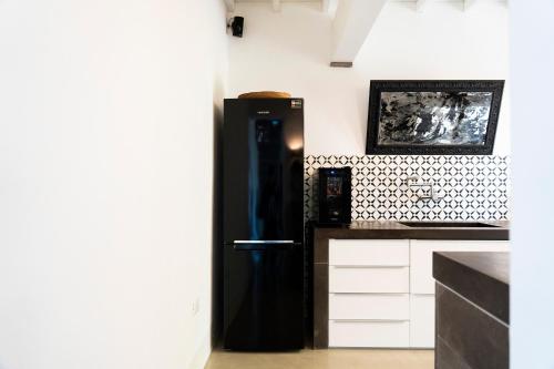 a black refrigerator in the corner of a kitchen at CASA MIRA in Orosei