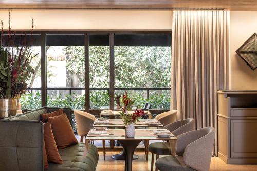 a living room with a couch and a table and chairs at L'Hotel PortoBay São Paulo in Sao Paulo