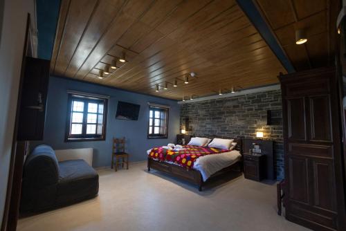 a bedroom with a bed and a brick wall at Tis Ouranias in Koukouli