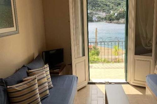 a living room with a blue couch and a sliding glass door at Kioni Apartments in Vathi, Ithaka